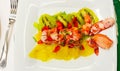 lobster salad with lobster and a bed of strawberries kiwis and pieces of pineapple