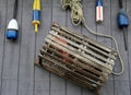 Lobster trap and colorful buoys on gray wall Royalty Free Stock Photo