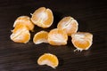 Lobules of mandarin on dark wooden table Royalty Free Stock Photo