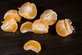 Lobules of mandarin on dark wooden table Royalty Free Stock Photo