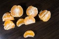 Lobules of mandarin on dark wooden table Royalty Free Stock Photo