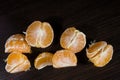 Lobules of mandarin on dark wooden table Royalty Free Stock Photo