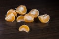 Lobules of mandarin on dark wooden table Royalty Free Stock Photo