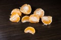 Lobules of mandarin on dark wooden table Royalty Free Stock Photo