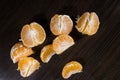 Lobules of mandarin on dark wooden table Royalty Free Stock Photo