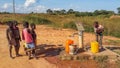 Local African children pumping drinking water at well built by c