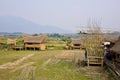 Local architectural house with unique roof design and under construction bamboo structure in foreground mountain in background