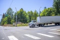 Local big rig semi truck with dry van semi trailer standing on the city crossroad intersection with red traffic light Royalty Free Stock Photo