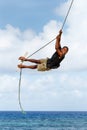 Local boy swinging on a rope swing in Lavena village on Taveuni