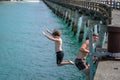 Local boys jumping of and climbing up Tolaga Bay Wharf