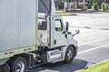 Local carrier day cab big rig semi truck with dry van semi trailer running on the city street for delivery Royalty Free Stock Photo