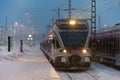 A local commuter train arriving at the Helsinki central railway in heavy snow storm