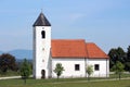 Local country church with white facade and new roof tiles surrounded with metal fence and freshly cut grass Royalty Free Stock Photo