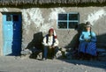 local couple rests in front of her rural hut at island Taquile in lake Titicaca