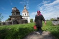 Local farmer with zinc bucket on a background of the church.