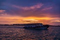 Local ferry swimming near Male town, Maldives at sunset