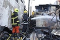 Local fireman help extinguish fire during house fire that gutted interior shanty houses Royalty Free Stock Photo