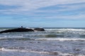 Local fisherman surrounded by water during high tide at Legzira, Morocco