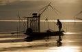 Local fisherman working on his boat in the beautiful en scenic of golden sunset.