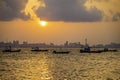 Local fishing boats anchor in front of Koh Larn with Pattaya as the sun rises in the background