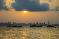 Local fishing boats anchor in front of Koh Larn with Pattaya as the sun rises in the background