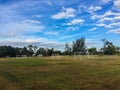 Local football stadium with goal post and blue sky and white clouds background in the rural area. Soccer field in the provincial Royalty Free Stock Photo