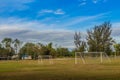 Local football stadium with goal post and blue sky and white clouds background in the rural area. Soccer field in the provincial Royalty Free Stock Photo