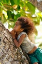 Local girl sitting on a palm tree in Lavena village, Taveuni Isl