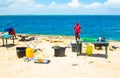 Local guides cooking with sandy ocean background in Mozambique