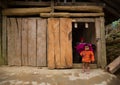 Local Hmong hill tribe woman uses sewing machine while her daughter poses for photo Royalty Free Stock Photo