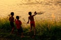 Local kids throuwing rocks in Nam Song River at sunset, Vang Vie