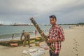 A local malagasy guy is selling a musical instrument on the beach