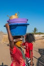 Local malagasy woman with a plastic bucket on head during their work in Morondava harbour.