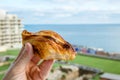 Local Maltese food called pastizz or pastizzi. Person hand holding Diamond-shaped small pie.