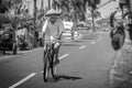 Local man in Bali riding a bicycle on a rural road in Indonesia.
