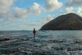 A local man in catches fish in the ocean on a sunny day to cook it for lunch. Indonesian man in red hoodie catches fish Royalty Free Stock Photo