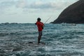 A local man in catches fish in the ocean on a sunny day to cook it for lunch. Indonesian man in red hoodie catches fish Royalty Free Stock Photo