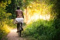 A local man rides his bike down a forest / jungle path just outs