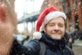 Local man in a Santa Claus hat takes selfie on street near the Manhattan Bridge in New York City on Christmas Eve during a Royalty Free Stock Photo