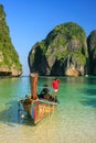 Local man standing in a longtail boat at Maya Bay on Phi Phi Leh Island, Krabi Province, Thailand