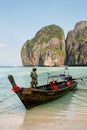 Local man standing in a longtail boat at Maya Bay on Phi Phi Leh Island, Krabi Province, Thailand