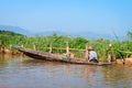 Local man in a traditional canoe rows past floating gardens on I