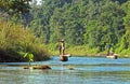 Local man traveling by rowboat at wild river in Chitwan National Park, Nepal. Royalty Free Stock Photo