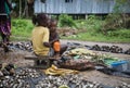 Local market, girl selling mussels and holding baby, Solomon Islands Royalty Free Stock Photo