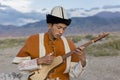 Local musician in traditional costumes playing Dutar, Issyk Kul Lake, Kyrgyzstan