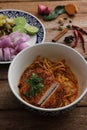 Local northern Thai food Egg noodle curry with fried pork on wood background Royalty Free Stock Photo