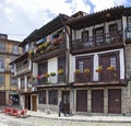 A local passes by the medieval buildings in the Santiago Square