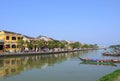 Local people, boats, yellow houses by the river, and tourists in Hoi An ancient town