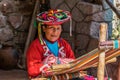 Local Peruvian village woman making colorful handmade textiles at the Awanacancha Textile site in Peru outside of Cusco.