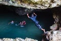 Local Polynesian teens playing and swimming in Veimumuni cave, while a girl jumping to the pool. Motion blur. Vavau, Tonga. Royalty Free Stock Photo